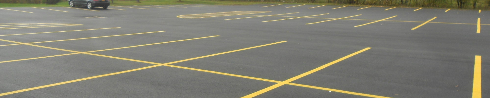 open parking lot with black car on fresh pavement