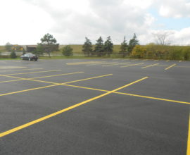 open parking lot with black car on fresh pavement