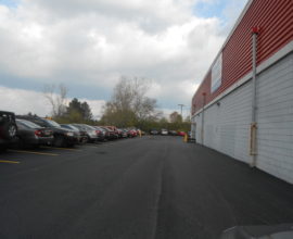 brick building with paved parking lot beside it