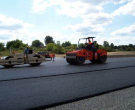 several workers smoothing the pavement