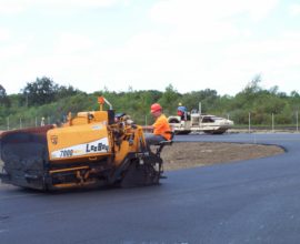 man on machine placing pavement onto ther oad