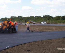 worker using a broom to smoothen the pavement