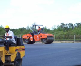 two workers on machines smoothing the pavement