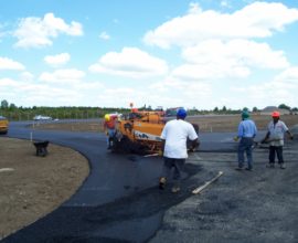 several workers dumping loose concrete over road